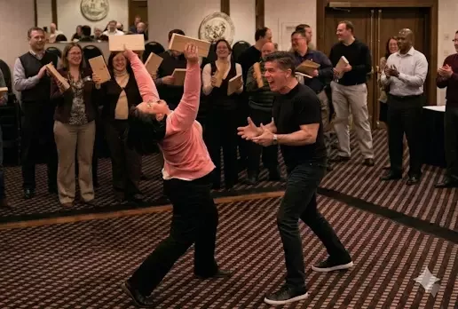 Corporate teams physicalizing the LEVEL 12 Breakthrough through the Board Break event, led by Senior Strategist Dan Perdue